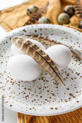 White background with white eggs and feathers.  White background. Top view