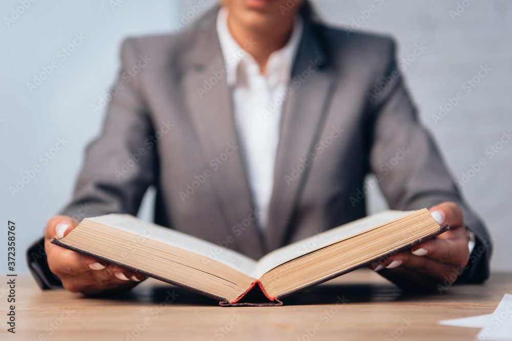selective focus of lawyer in suit reading book in office selective focus of lawyer in suit reading book in office