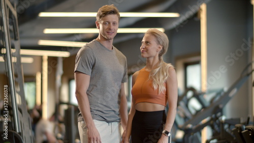 Winners couple showing like signs in sport club. Couple enjoying results at gym