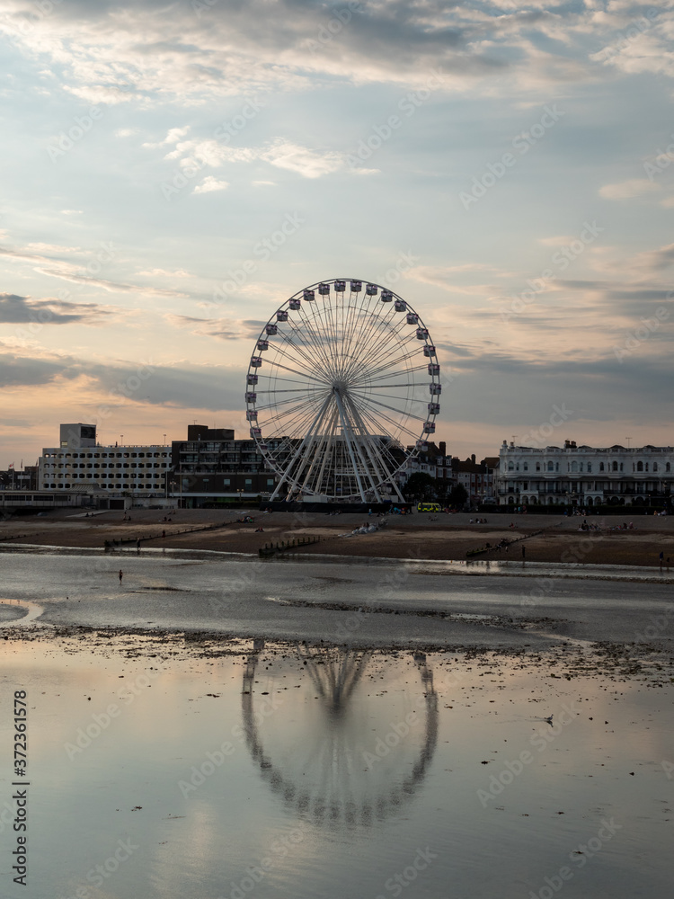 Seaside town landscape during low tide, with Ferris wheel 