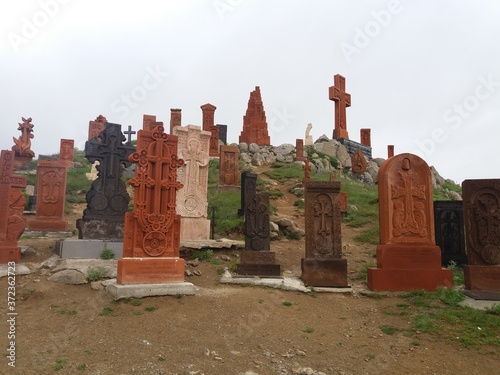 Armenian cross-stone on green hill is a carved, memorial stele bearing a cross, and often with additional motifs. Khachkars are characteristic of Medieval Christian Armenian art. photo