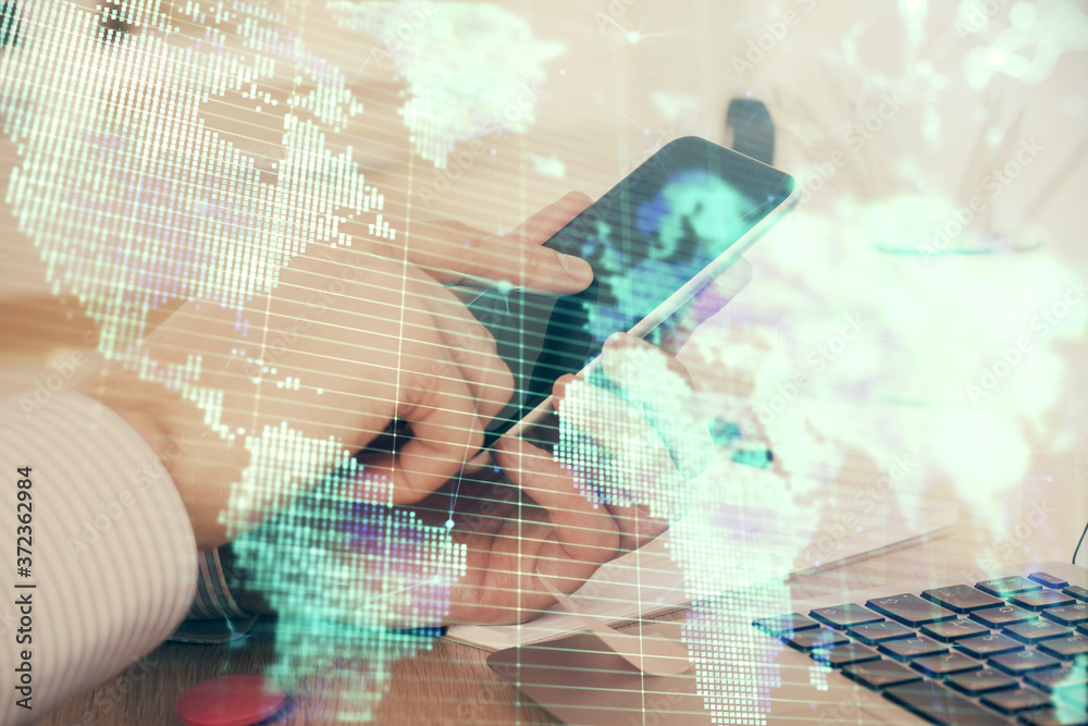 Double exposure of man's hands holding and using a phone and international business theme drawing. Double exposure of man's hands holding and using a phone and international business theme drawing.