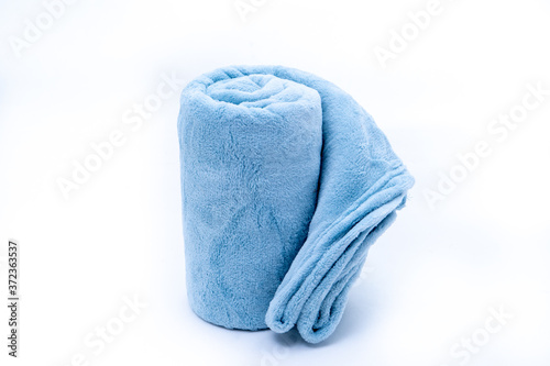 Rolled up blue coral fleece throw isolated on white background
