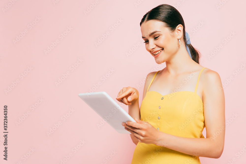 brunette young woman using digital tablet isolated on pink brunette young woman using digital tablet isolated on pink