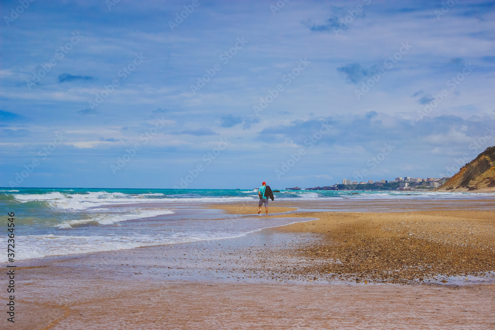 people walking on the beach. man walking on beach. ocean shore with blue sky and sand