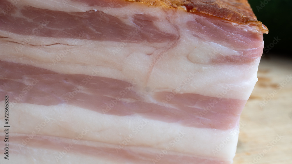 Fototapeta Smoked bacon meat with lots of fat on it in an extreme close up. The meat is salt-cured and from a pig's belly or back.