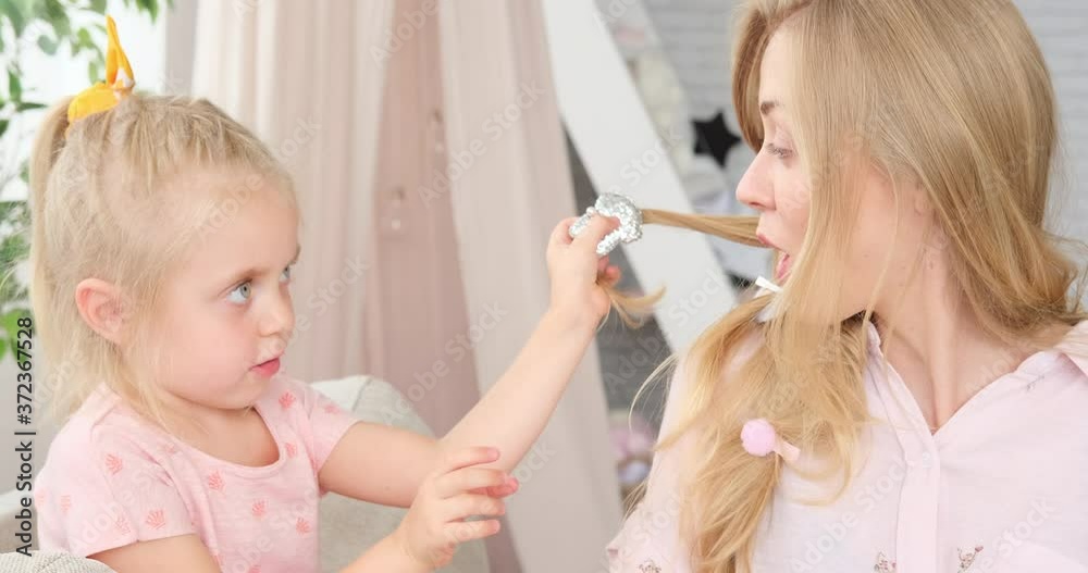 Loving mother embracing and encouraging daughter learning to do hairstyle at home Loving mother embracing and encouraging daughter learning to do hairstyle at home