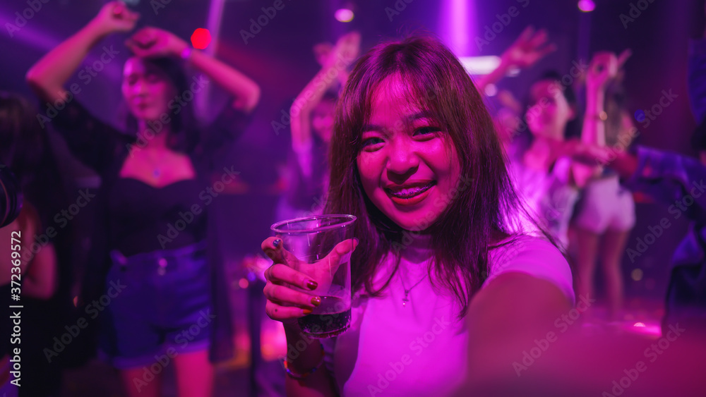 young asian woman in nightclub with colorful light