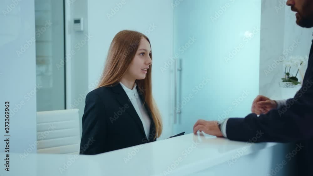 Handsome young man fiil the form at the reception in clinic hospital document registration medical healthcare male patient treatment service beard conversation slow motion Handsome young man fiil the form at the reception in clinic hospital document registration medical healthcare male patient treatment service beard conversation slow motion