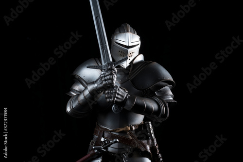 Fotografia knight with sword blue velvet background