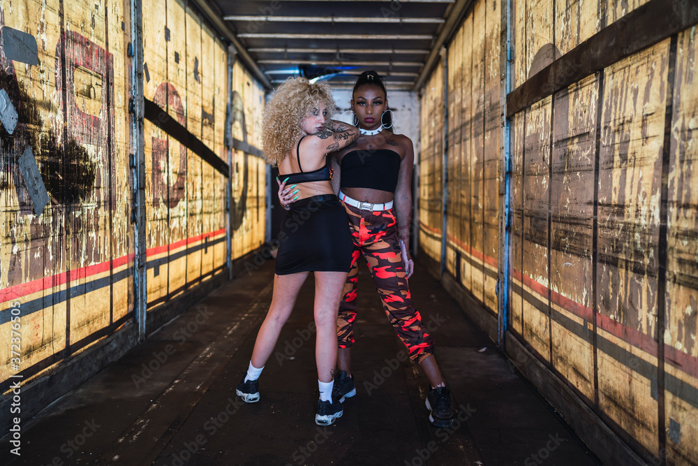 Chicas jovenes rubia con rizos y negra estilo urbano posando Stock Photo |  Adobe Stock