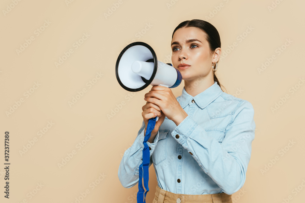brunette woman in denim shirt with loudspeaker isolated on beige brunette woman in denim shirt with loudspeaker isolated on beige