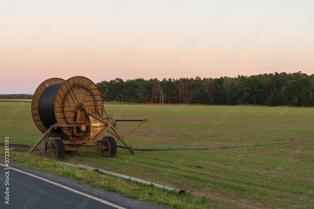 Eine Schlauchtrommel - Beregnungsanlage auf einem Feld Eine Schlauchtrommel - Beregnungsanlage auf einem Feld