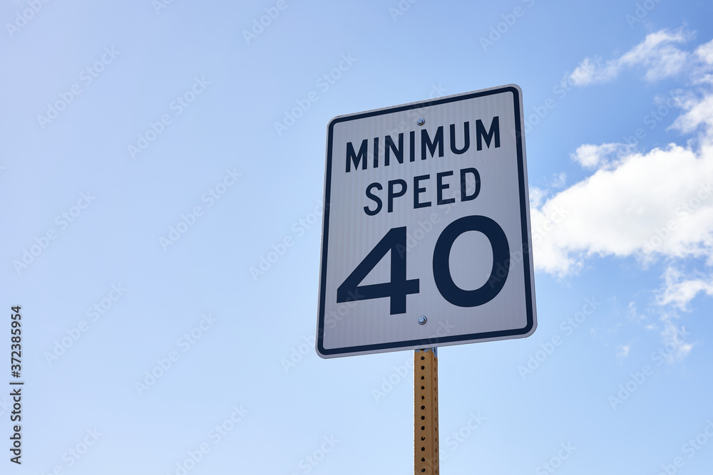 40 mph minimum speed sign on a highway to keep a smooth traffic flow. Speed zone traffic sign against blue sky and clouds. 40 mph minimum speed sign on a highway to keep a smooth traffic flow. Speed zone traffic sign against blue sky and clouds.
