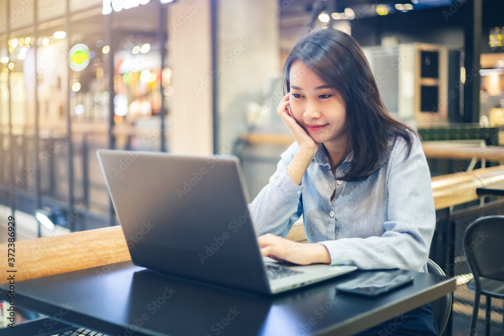 Young Asian woman using laptop computer and tablet PC to working in the modern co working space Young Asian woman using laptop computer and tablet PC to working in the modern co working space