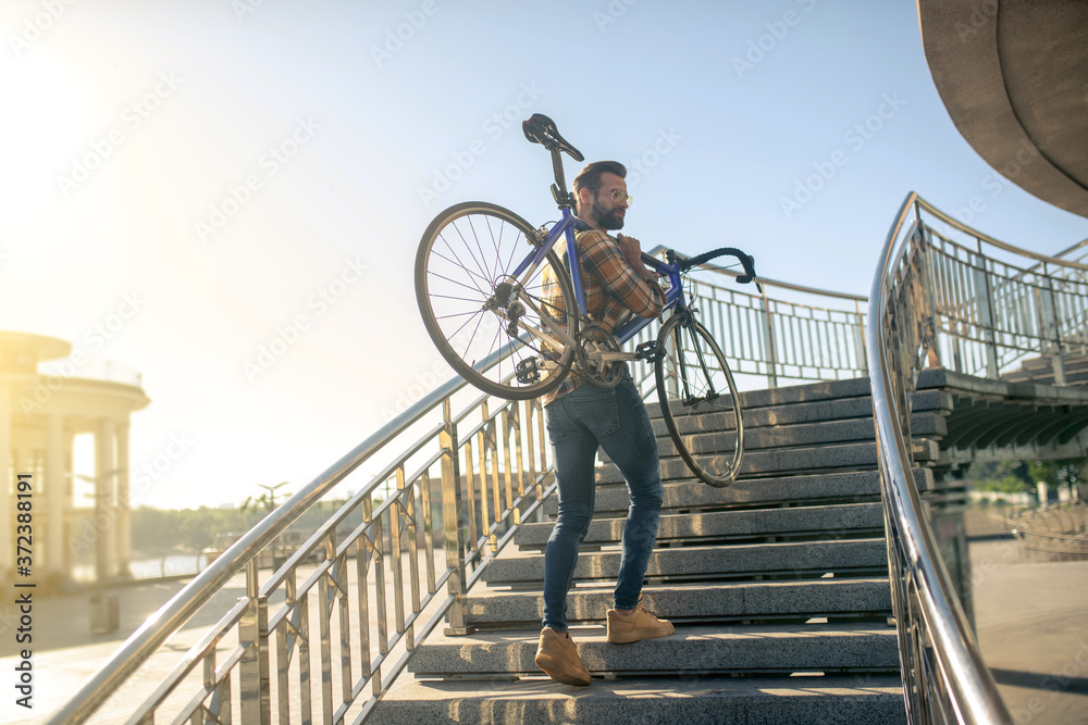 Man with bicycle on the city bridge