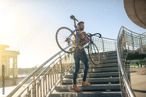 Man with bicycle on the city bridge