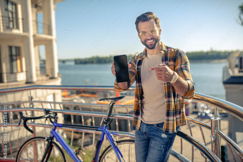 Man showing smartphone screen while standing in outdoors