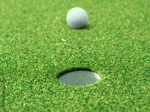 golf ball on lip of cup of lovely beautiful golf course