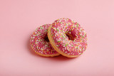 Tasty donut on patel pink background.
