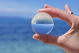 Reflections of the clouds and calm sea in a cloudy day in a crystal ball, environment concept