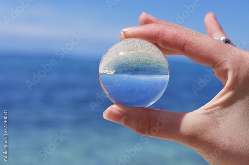 Reflections of the clouds and calm sea in a cloudy day in a crystal ball  environment concept