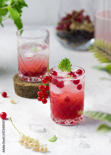Fresh, cold lemonade with berries, lemon and mint in a glass on a light background. summer, vacation, holidays, sea concept 