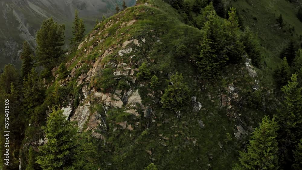 Aerial Drone View of Lone Professional Hiker with Trekking Bag Climbing on top of Mountain. Wide view of Mountain Peak and Landscape. Aerial Drone View of Lone Professional Hiker with Trekking Bag Climbing on top of Mountain. Wide view of Mountain Peak and Landscape.