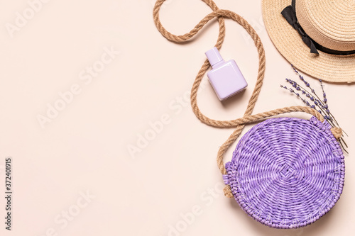 Straw hat and bag with perfume bottle on light background