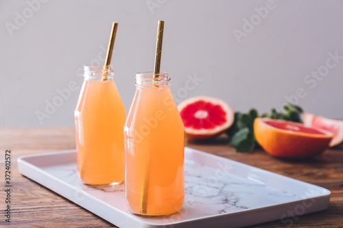 Bottles of fresh grapefruit juice on table