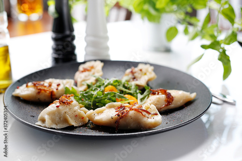 Dumplings with meat. Traditional homemade meat dumplings served on a black plate. Suggestion to serve the dish. Top view.