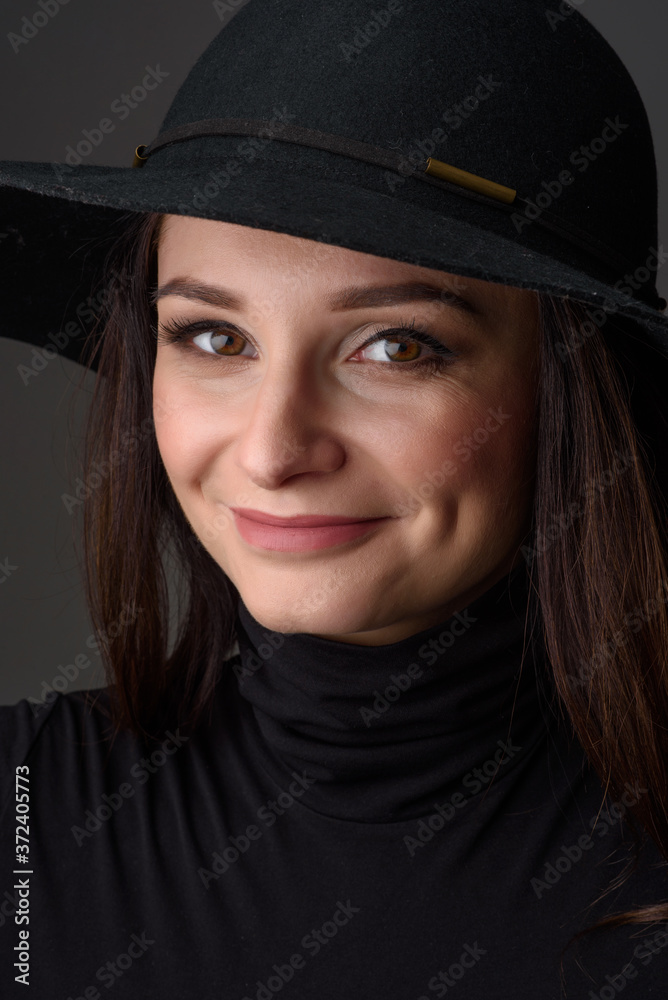 Close-up portrait of a beautiful woman wearing a black hat. Close-up portrait of a beautiful woman wearing a black hat.