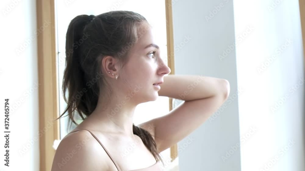 tired sporty young brunette caucasian girl with ponytail wearing beige top wipes sweat from her forehead after effective workout at home. Healthy lifestyle, fitness training, hobby, leisure, activity tired sporty young brunette caucasian girl with ponytail wearing beige top wipes sweat from her forehead after effective workout at home. Healthy lifestyle, fitness training, hobby, leisure, activity