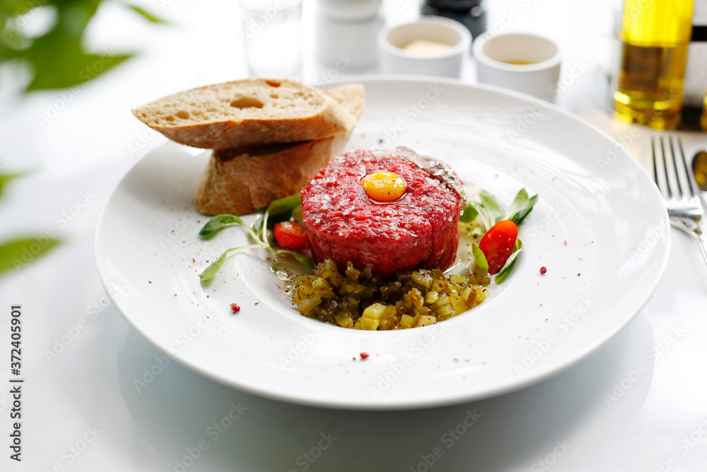 Beef tartare with egg and pickles. Appetizing appetizer. Suggestion to serve the dish. Culinary photography. Beef tartare with egg and pickles. Appetizing appetizer. Suggestion to serve the dish. Culinary photography.