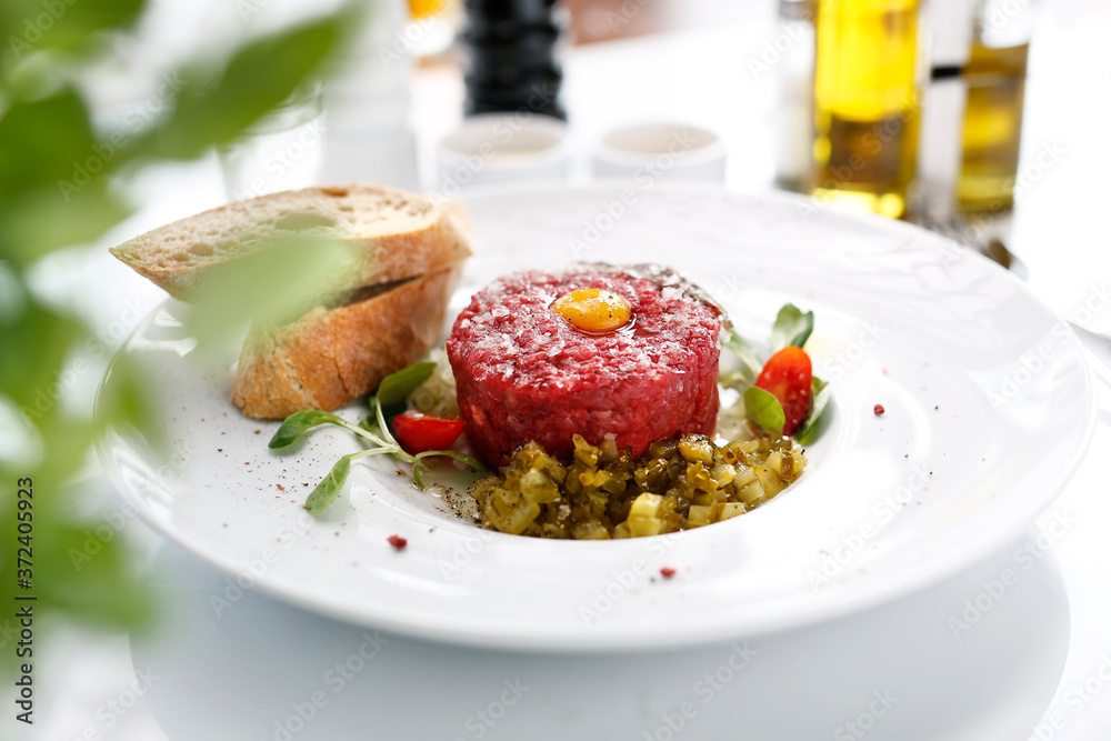Chopped beef tenderloin, beef tartare with yolk. Appetizing appetizer. Suggestion to serve the dish. Culinary photography. Chopped beef tenderloin, beef tartare with yolk. Appetizing appetizer. Suggestion to serve the dish. Culinary photography.