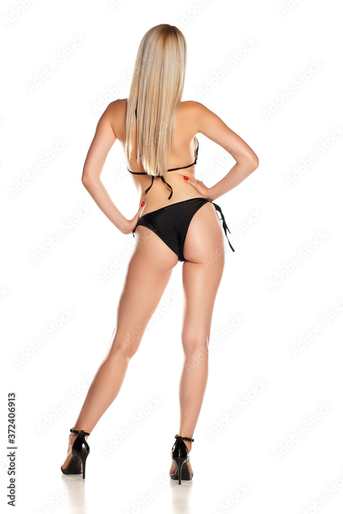 Woman in black bikini, rear view, isolated on white background. Woman in black bikini, rear view, isolated on white background.