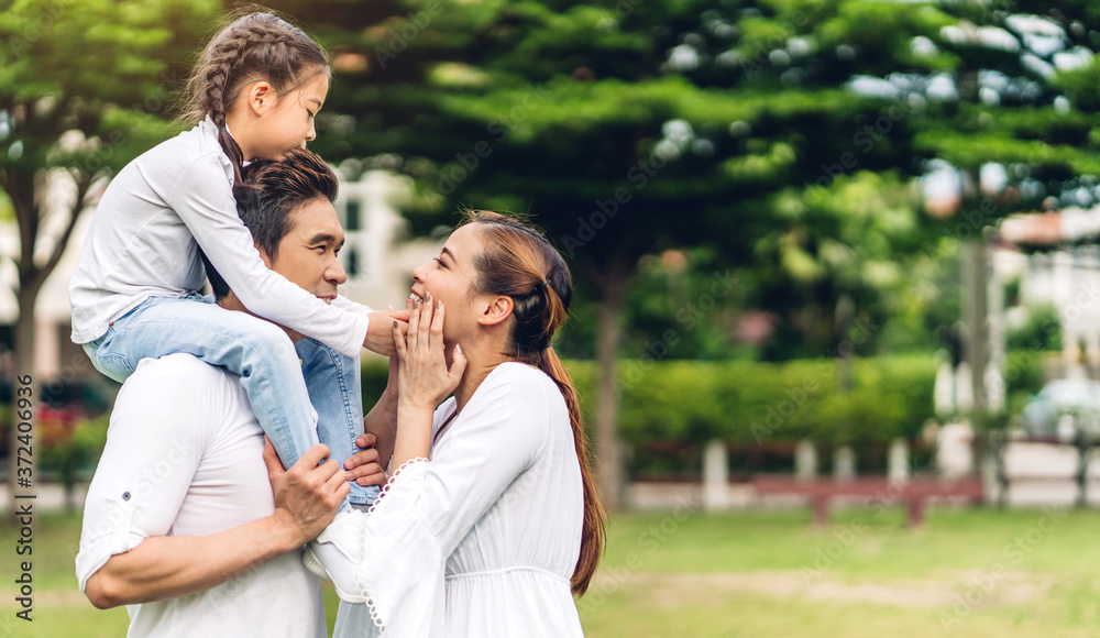 Portrait of enjoy happy love asian family father and mother holding little asian girl on back smiling playing and having fun moments good time in summer park at home Portrait of enjoy happy love asian family father and mother holding little asian girl on back smiling playing and having fun moments good time in summer park at home