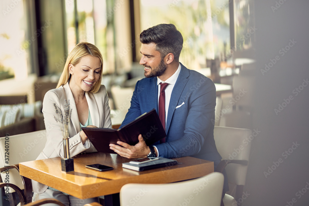 Happy business colleagues reading menu in a restaurant. Happy business colleagues reading menu in a restaurant.
