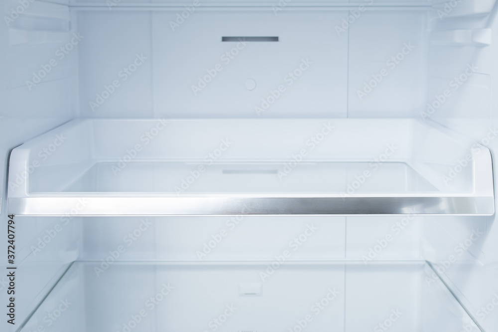 Background empty shelves in the refrigerator. Inside of clean and empty refrigerator with shelves. Background empty shelves in the refrigerator. Inside of clean and empty refrigerator with shelves.