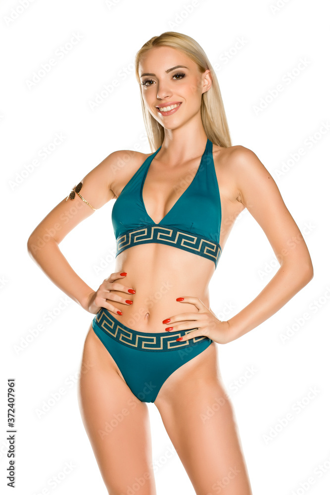 Pretty young smiling lady in blue bikini swimsuit on white background Pretty young smiling lady in blue bikini swimsuit on white background