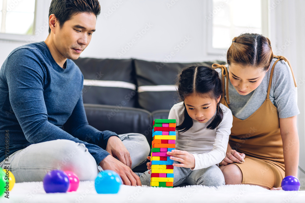 Portrait of enjoy happy love asian family father and mother with little asian girl smiling playing with toy build wooden blocks board game in moments good time at home Portrait of enjoy happy love asian family father and mother with little asian girl smiling playing with toy build wooden blocks board game in moments good time at home