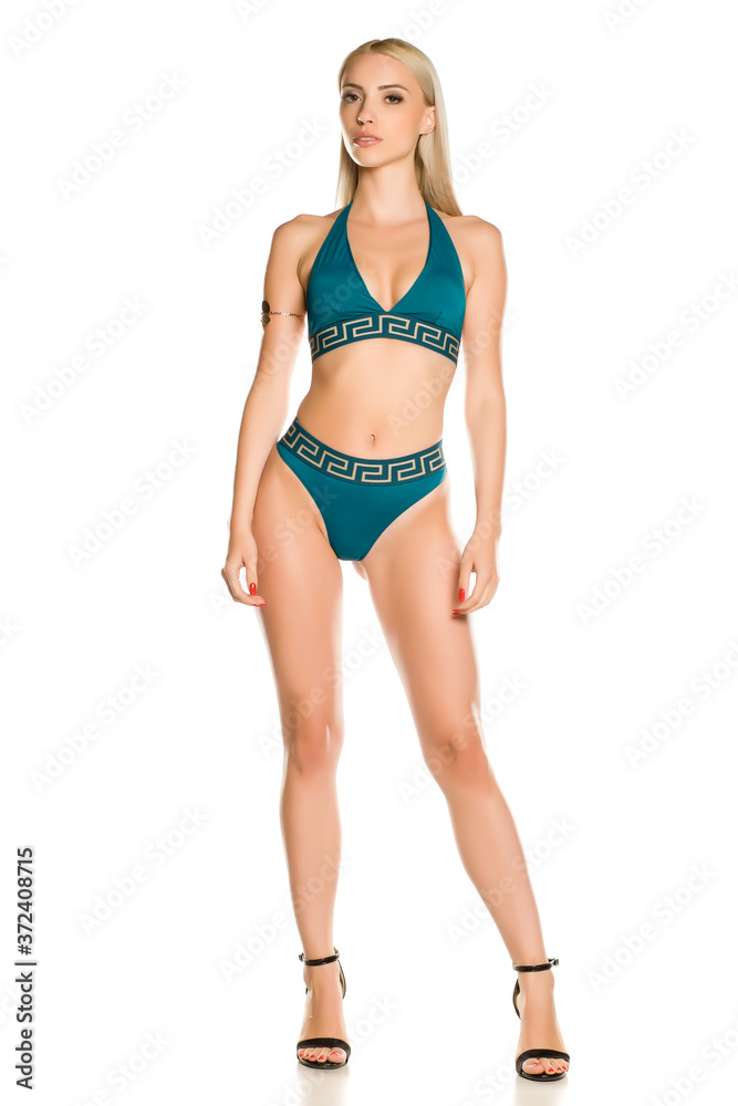 Pretty young lady in blue bikini swimsuit and sandals on white background Pretty young lady in blue bikini swimsuit and sandals on white background