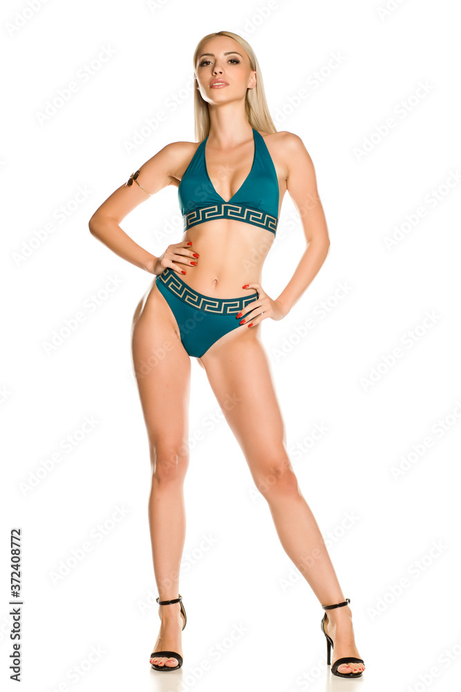 Pretty young lady in blue bikini swimsuit and sandals on white background Pretty young lady in blue bikini swimsuit and sandals on white background