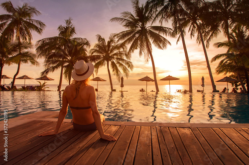 beach vacation in luxury hotel, tropical holidays in luxurious resort, woman sitting near swimming pool