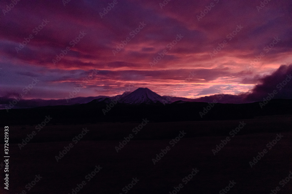 Beautiful pink and purple cloudy sunrise over the snowy mountains