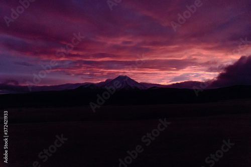 Beautiful pink and purple cloudy sunrise over the snowy mountains