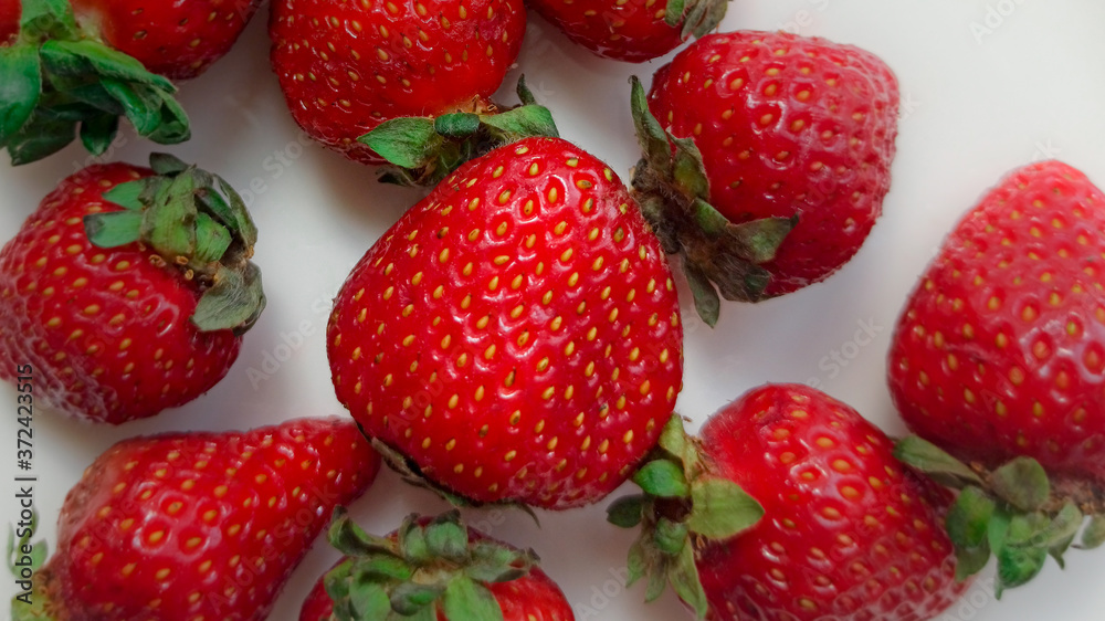 Strawberries on a white plate and white plate. Selective focus Strawberries on a white plate and white plate. Selective focus
