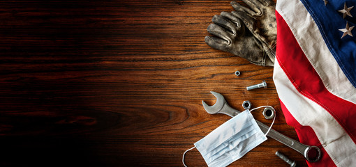 American National Holiday. US Flags with American stars, stripes and national colors. Construction and manufacturing tools, face mask, on wooden background. Labor day background concept.
