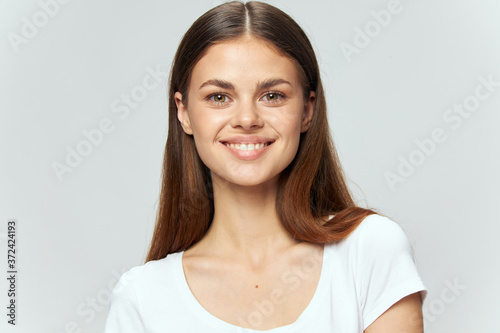 Portrait of a happy woman in a white t-shirt charming smile brunette joy 