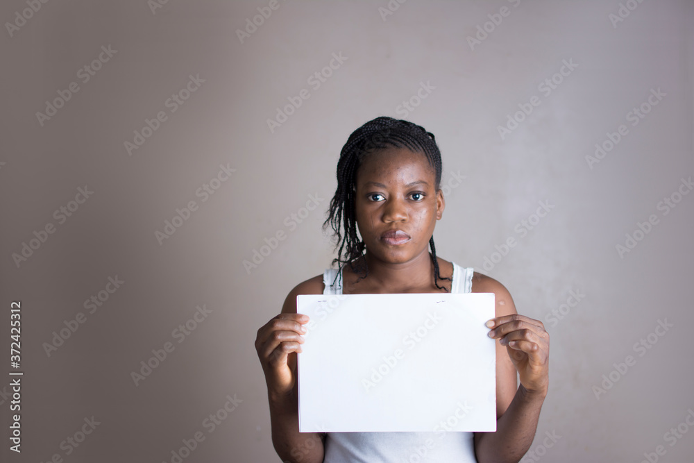 A young African woman holding a blank paper A young African woman holding a blank paper